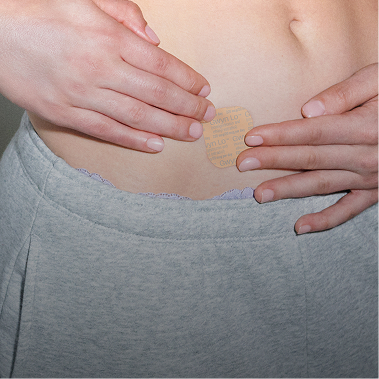 Person applying the birth control patch to the stomach